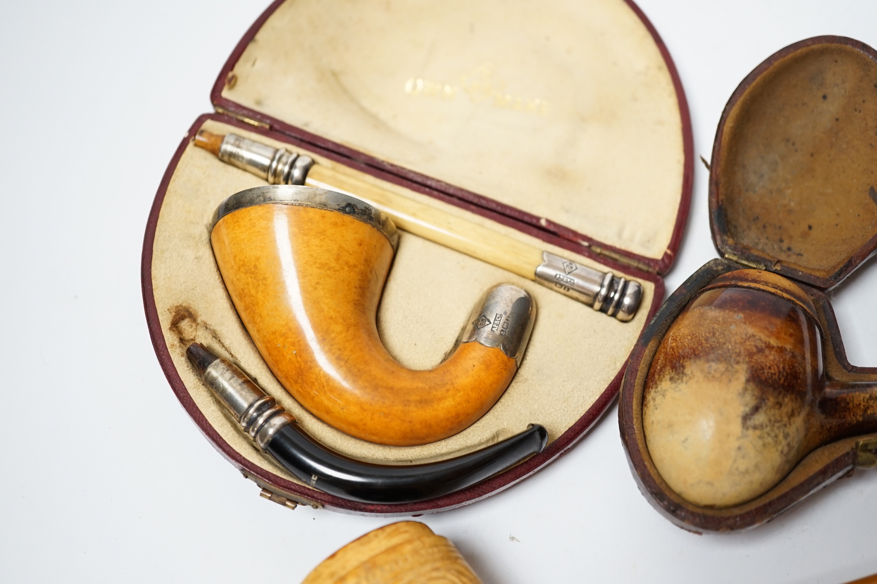 Three Meerschaum pipes, one 9ct gold mounted, one silver mounted, two cases